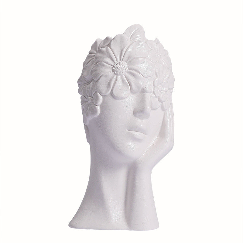 Matte white ceramic vase in the form of a female head with flower and leaf relief