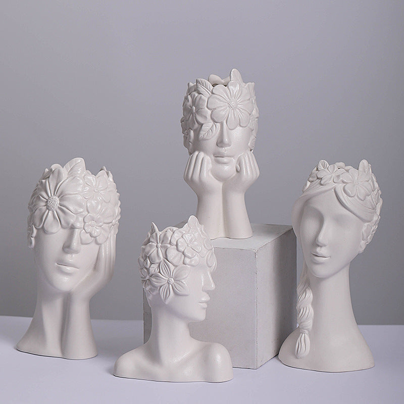 Set of matte white ceramic head vases with floral relief faces in three views