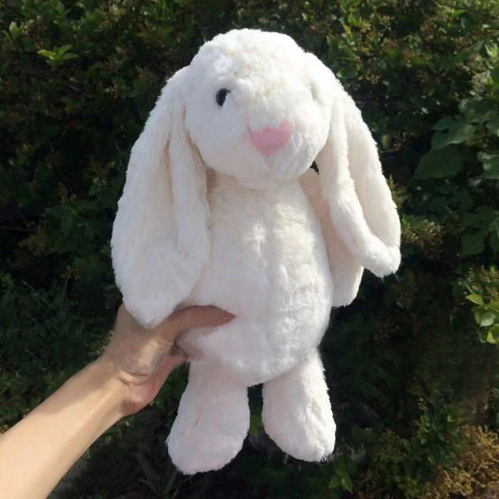 Long-eared bunny plush toy, white, held in hand with soft fuzzy texture