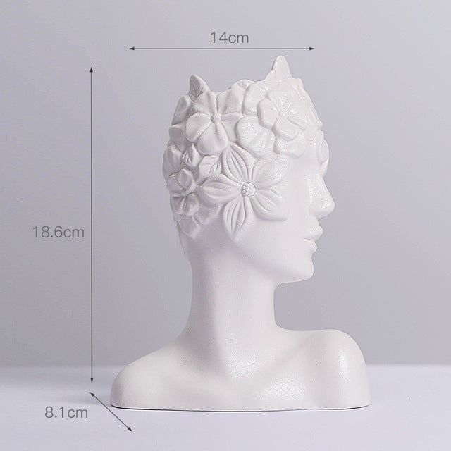 Matte white ceramic vase shaped like a female head with raised flower detailing