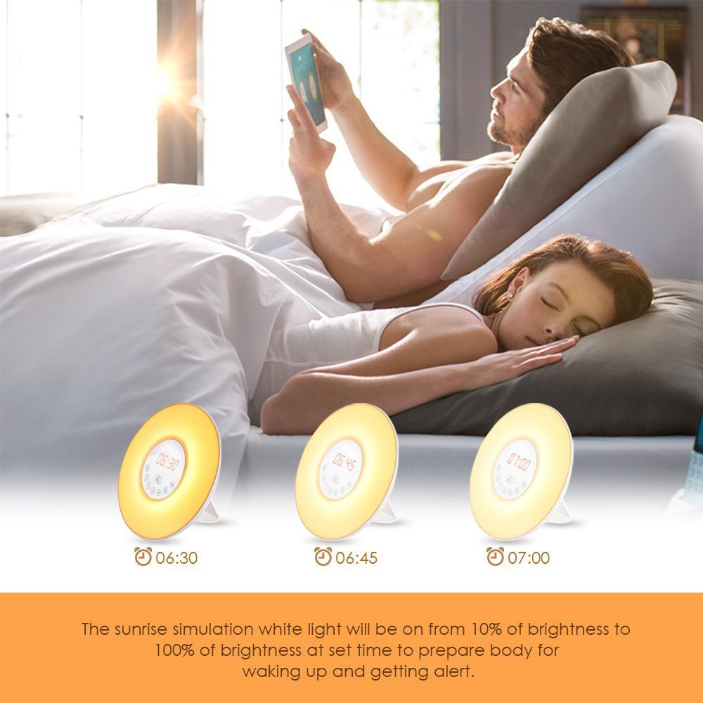 Colorful bedside alarm clock radio showing times, three devices with soft yellow glow