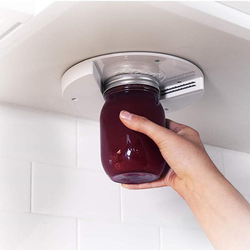 Universal jar opener attached over jar lid with hand gripping the bottle