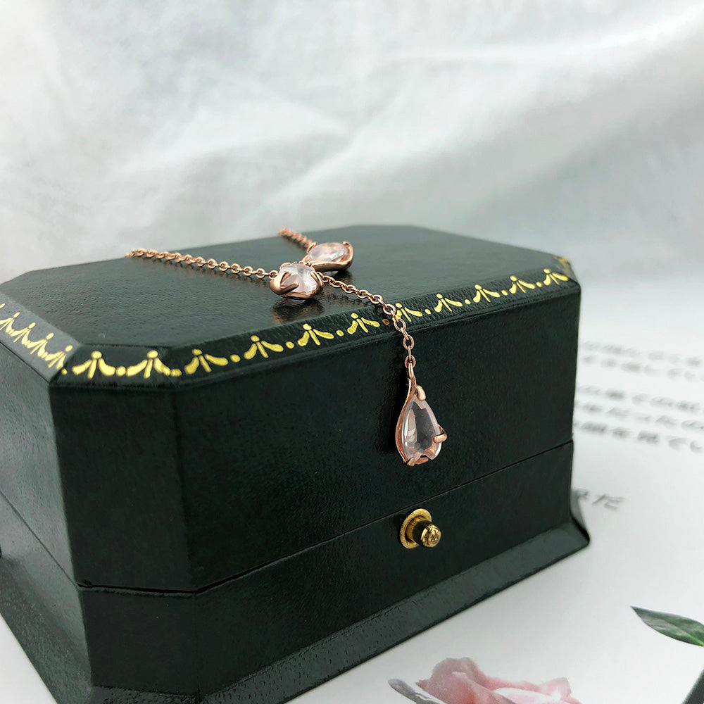 Pink quartz teardrop pendant necklace with chain links on dark jewelry box