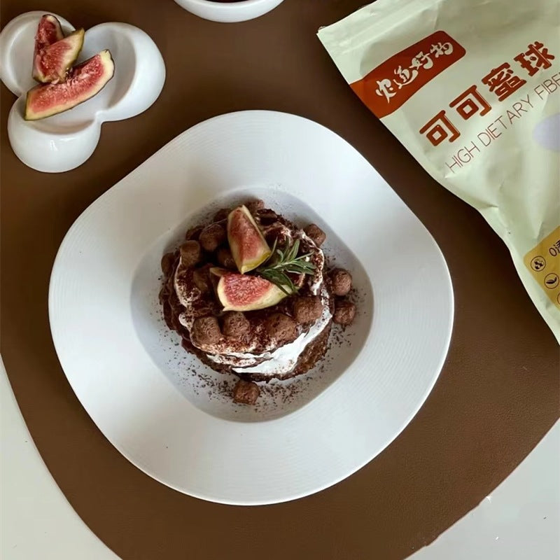 White wave-shaped ceramic plate with an oval center well, served with snacks