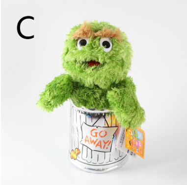 Green Elmo plush doll with round eyes, curly fuzzy green fur, leaning forward