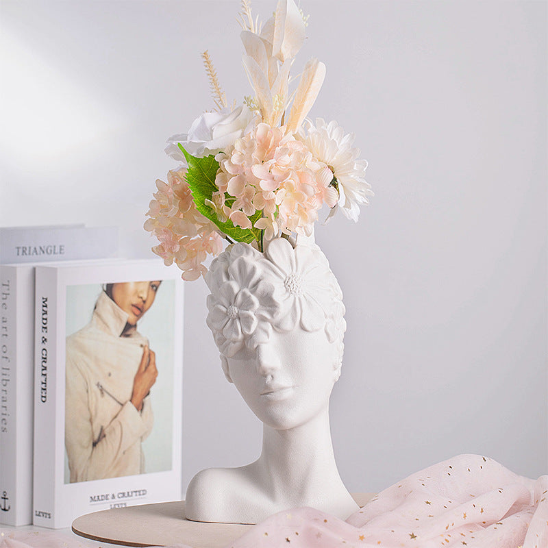 Matte white ceramic vase head design holding a bouquet with white and peach flowers