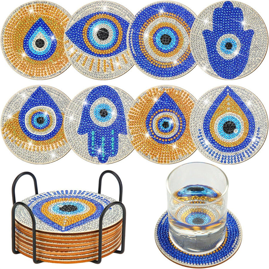 8 diamond coasters with blue/gold eye and hamsa designs on stand
