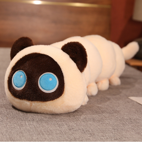 White plush cat pillow with brown ears and large blue eyes