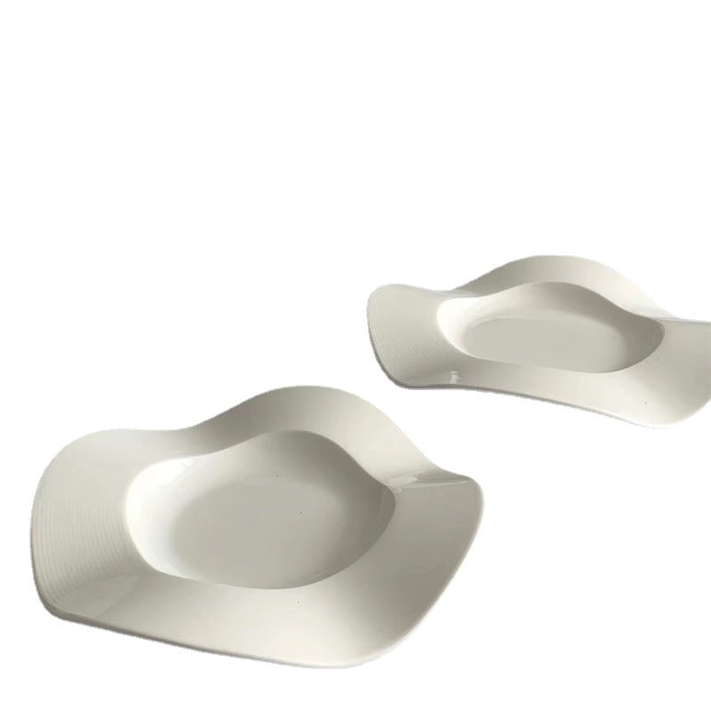Pair of white wave-shaped ceramic side plates with sculpted scallop edges and center wells