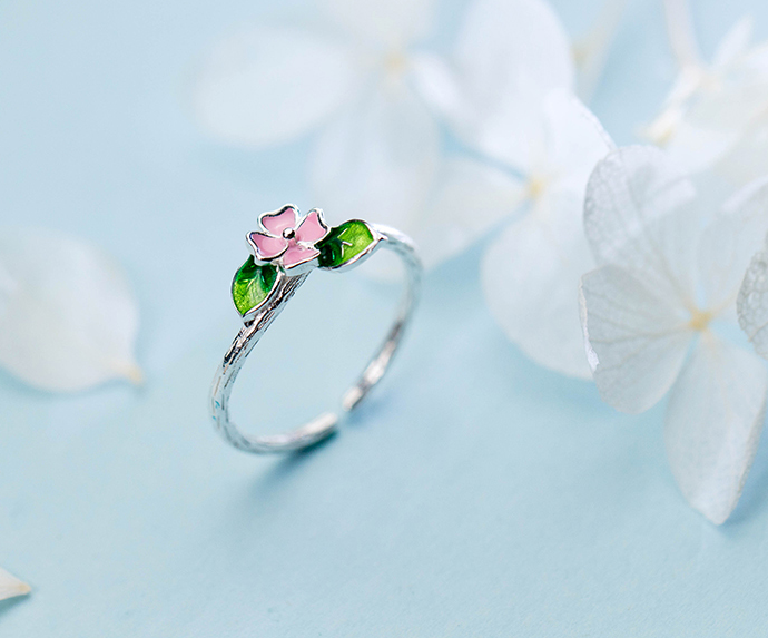 Pink floral open silver ring with green leaf details on curved band