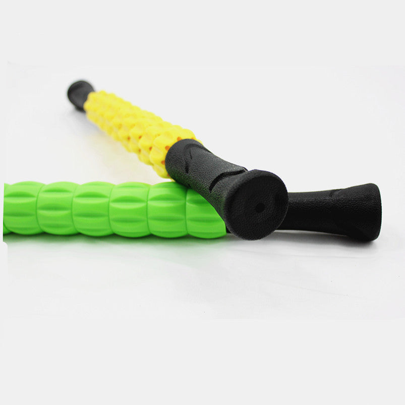 Green muscle massage stick with black handle and raised roller beads; yellow stick behind it.