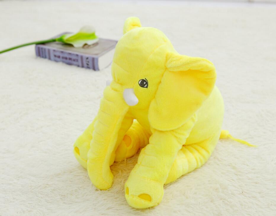 Yellow plush elephant toy and pillow companion, curled up with soft ears and trunk