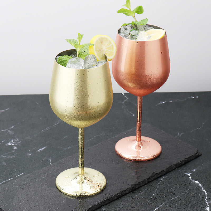 Copper and gold-plated wine goblets with ice cubes, rounded bowls and pedestal bases