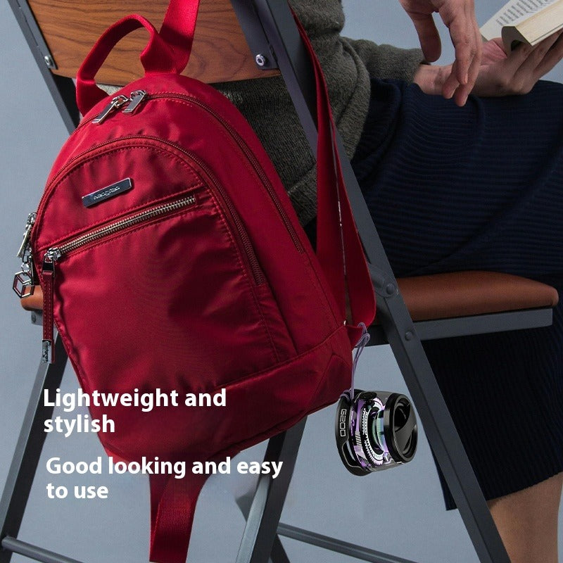 Mini Bluetooth magnetic wireless speaker clipped to a red backpack, visible LED ring