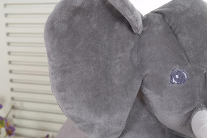 Gray plush elephant pillow companion close-up, stitched eye and ear