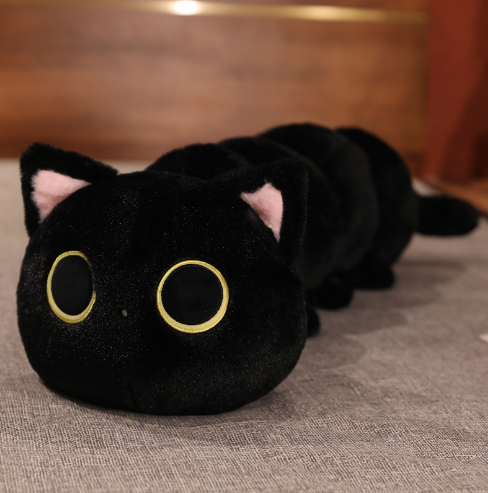 Black plush cat pillow with big yellow-ring eyes and rounded ears