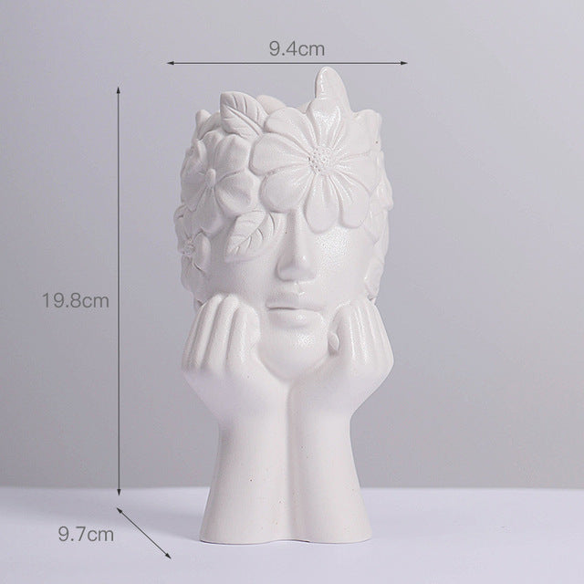 Matte white ceramic vase with female head silhouette and large flower relief on hair