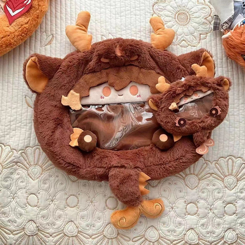 Brown plush dragon bag with cartoon eyes and padded outer plush, open inner pocket