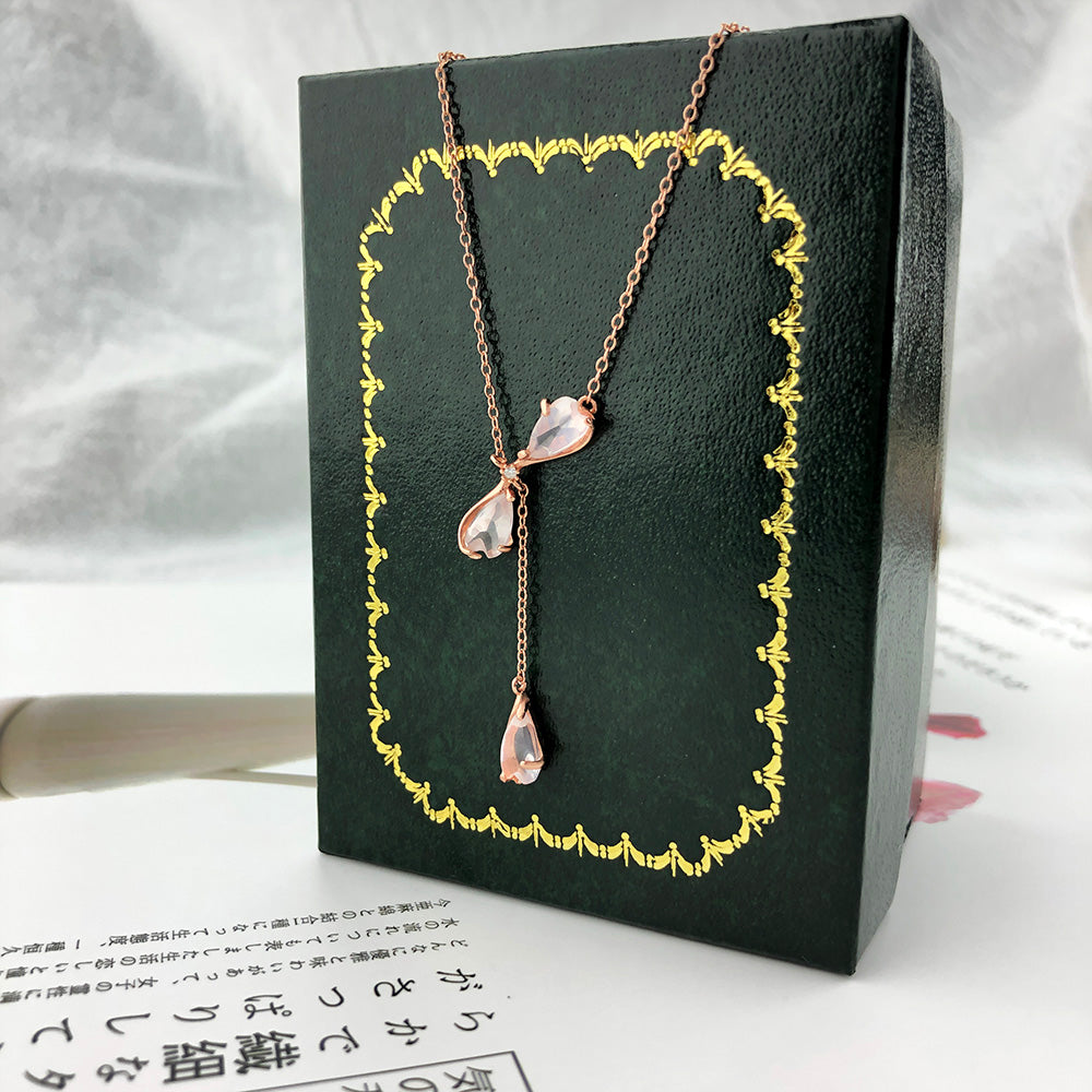 Necklace with multiple pink teardrop quartz drops on dark jewelry box, set
