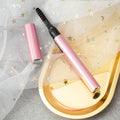 Electric eyelash curler in pink with heated black comb tip, long barrel design