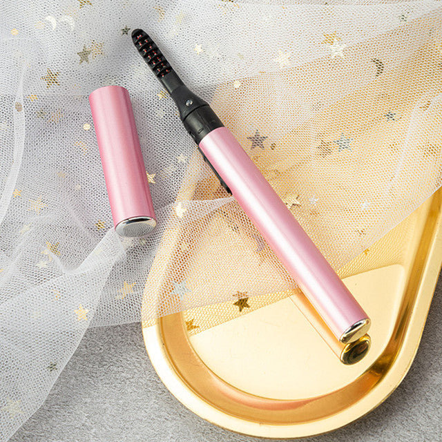Electric eyelash curler in pink with heated black comb tip, long barrel design