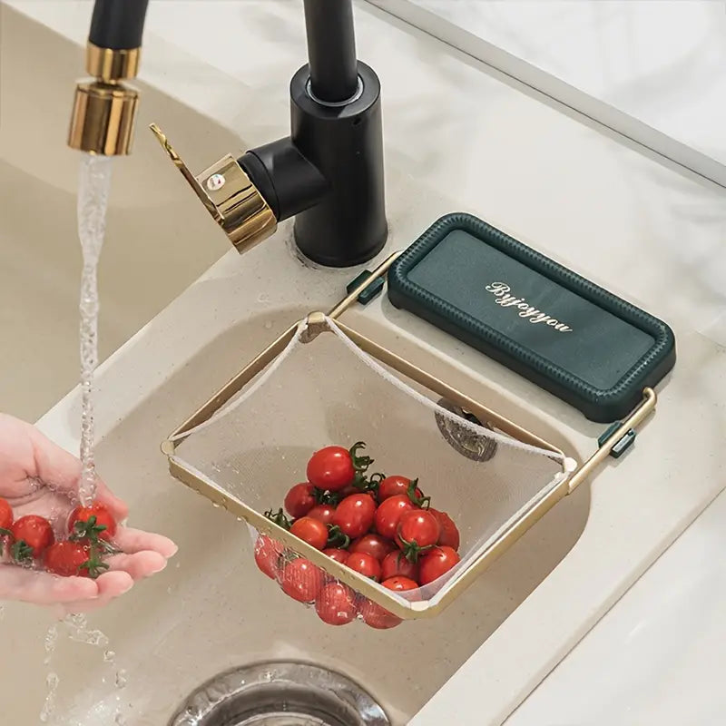 Kitchen sink strainer rack with teal mat and gold frame over a drain tray