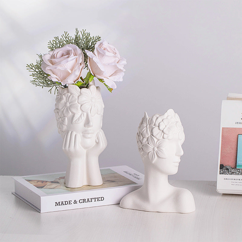 Matte white ceramic head vase with floral relief holding pink and white roses