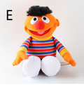 Orange Elmo plush doll with striped shirt, open mouth, white belly and feet